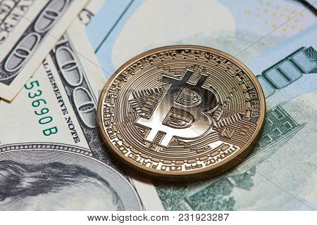 Gold coin bitcoin on dollar bills background