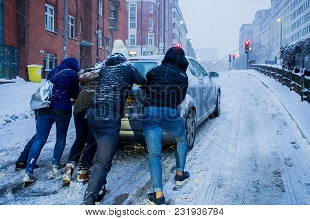 Birmingham, United Kingdom - March 02 2018 : Unidentified People Pushing A Car Which Is Slipping Dur