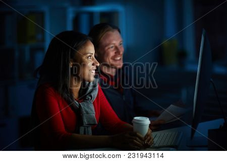 Businessman and businesswoman working on computer till night