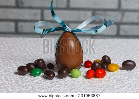 Easter Chocolate Egg With Lots Of Chocolate Candies In Decoration