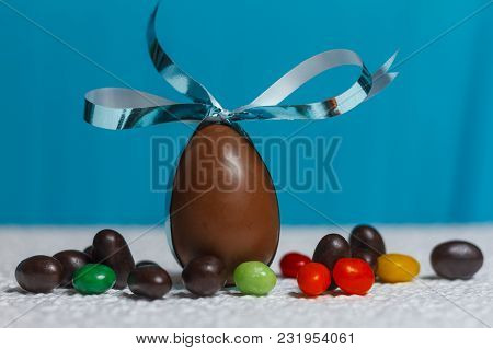 Easter Chocolate Egg With Lots Of Chocolate Candies In Decoration