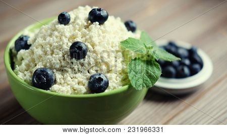 Cottage cheese and blueberry in a bowl on a table. Good breakfas