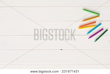 Colorful wax crayons for drawing on the white wooden table. Top view and copyspace. space for caption, empty space for text