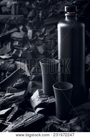 Original Black Matte Bottle Of Vodka Or Tequila And Black Shot Glass .on Charcoal Background. Black