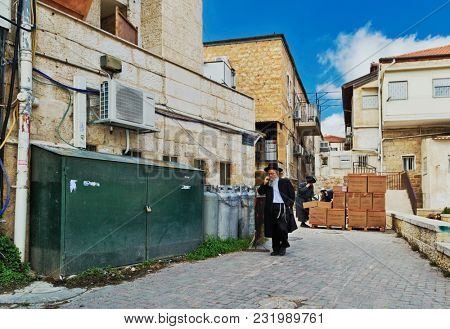 JERUSALEM, ISRAEL - DECEMBER 29, 2016: Orthodox Jewish man with mobile phone walk at street at jewish quarter in Jerusalem. 