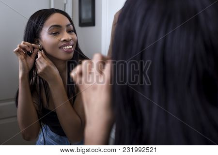 Pretty Black Female Getting Ready In Front Of A Bathroom Mirror Putting On A Ring And Jewelry.  She 