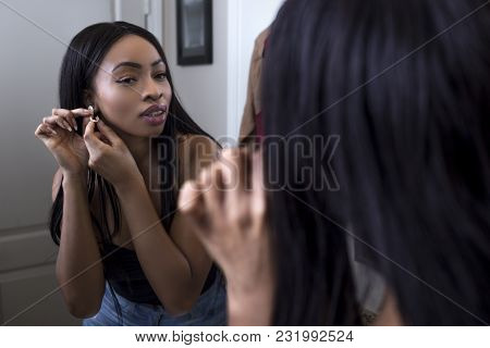Pretty Black Female Getting Ready In Front Of A Bathroom Mirror Putting On A Ring And Jewelry.  She 