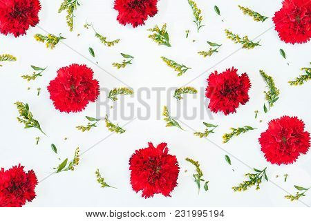 Floral Pattern Made Of Red Carnations, Green Leaves, Branches On White Background. Flat Lay, Top Vie