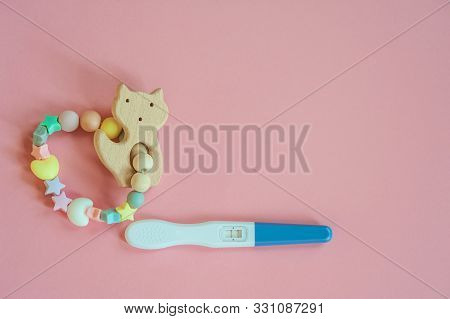 Wooden Baby Teether With Beads And Pregnancy Test. Minimalistic Flat Lay With A Wooden Toys Cat An I