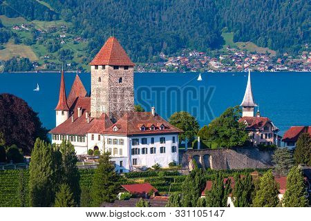 Aerial View Of Spiez Church And Castle On The Shore Of Lake Thun In The Swiss Canton Of Bern At Suns