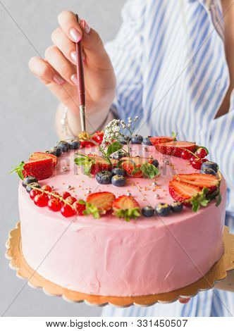 The Confectioner Decorating With Brush The Cake. Girl Birthday Cream Cheese Pink Cake. Golden Berrie