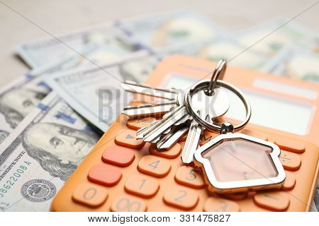 Keys With House Trinket And Calculator On Money, Closeup Real Estate Agent Service