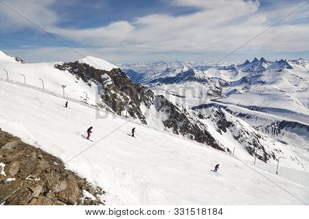 Skiing slopes in the French Alps, Alpe d'Huez, unrecognizable skiers descending