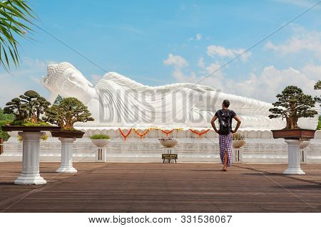 Young Man Travel In Bali, Indonesia. Tourist Walk In Buddhist Temple Vihara Dharma Giri, See At Lyin