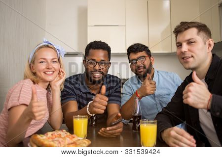 Young Friends Using Phone In Kitchen
