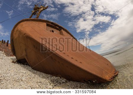 Old Rusty Wreck And Rocky Beach In Baltic Sea, Natural Environment. Osmussaar, Estonia, Europe.