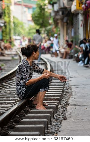 Hanoi, Vietnam - 18th October 2019:a Lone Asian Woman Sits On The Railway Track At Train Street In V