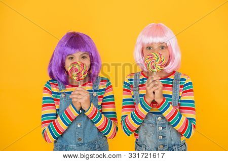 Sugary Food To Keep For Yourselves. Small Children Hold Lollipops Yellow Background. Little Girls En