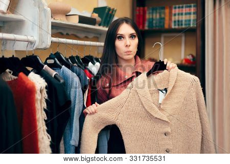 Woman Picking A Sweater To Try On In A Clothing Store