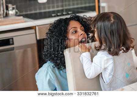 Smiling Mom Playing Peekaboo With Her Cute Little Daughter