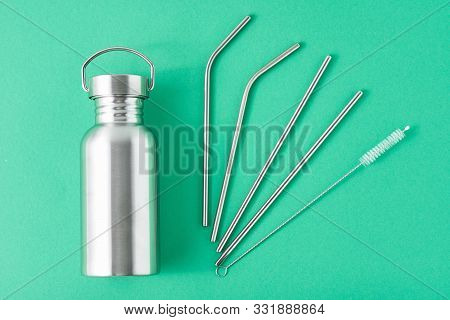 Reusable Plastic Free Items On Green Background. Top View Of Aluminun Bottle And Metal Tubes. Zero W