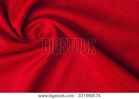 Close-up Fragment Of Crumpled Red Polyester Fabric. Concept Of High-quality Raw Materials For Clothi