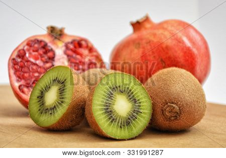 Pomegranate And Kiwi Fruits On The Wooden Table