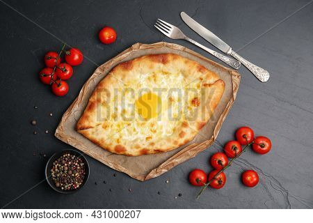Fresh Delicious Adjarian Khachapuri Served On Black Table, Flat Lay