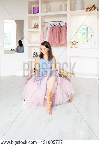 Young Joyful Charming Brunette Lady In Pink Tutu-skirt Sitting On Cozy Ottoman In Dressing Room, Hol