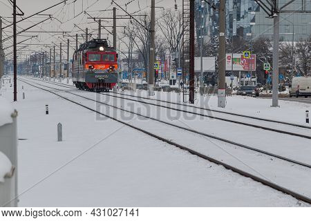 Electric Locomotive Vl80 Rides Through A Winter City. A Gray Winter Cityscape. Krasnodar, Russia, Fe
