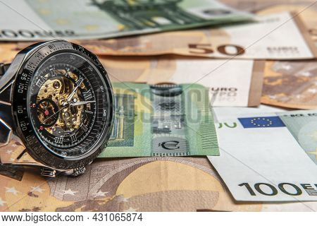 Time Is Money.a Beautiful Mechanical Watch In Close-up Lies On The Euro Money.manual Counting Of Eur