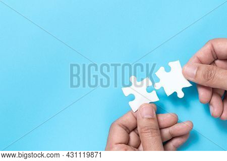 Hand Push A Piece Of Jigsaw Puzzle To Complete The Mission For Business Merging Concept Or Coorperat