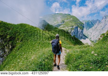 A Woman With A Backpack Stands On Top Of A Mountain, The Girl Travels To Beautiful Places, Reaching 