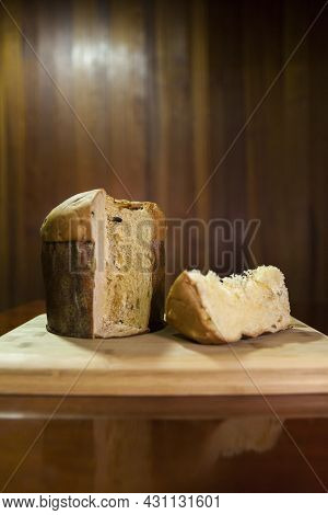 Panettone Slice On The Table. Panettone Cut On Wooden Table And Textured Background. Panettone Conce