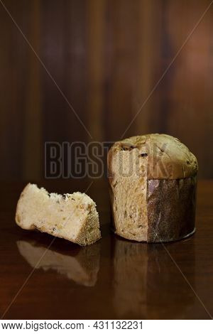 Panettone Slice On The Table. Panettone Cut On Wooden Table And Textured Background. Panettone Conce