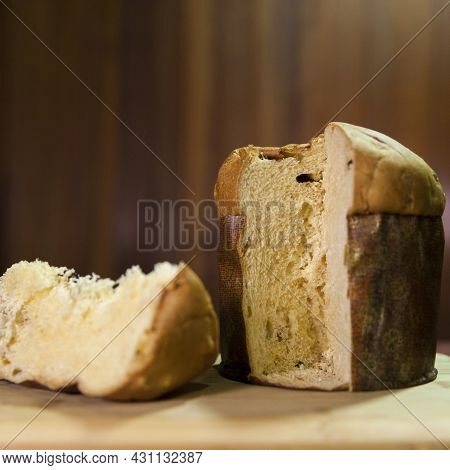 Panettone Slice On The Table. Panettone Cut On Wooden Table And Textured Background. Panettone Conce