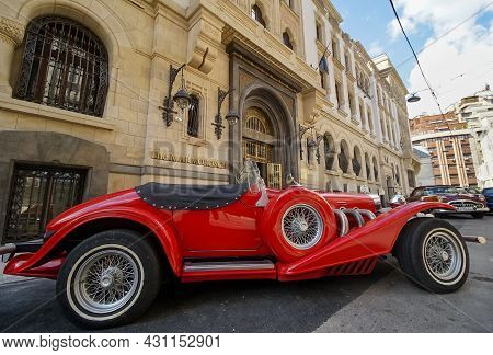 Bucharest, Romania - August 19, 2021: A Red Excalibur 1970s Ss Car Is Parked In Front Of The Marmoro