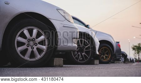 Many Cars Are Parked In A Large Parking Lot. Arranged In A Long Line Was The Time When The Sun Was S