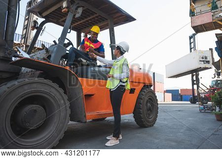 Black Foreman Worker Driving Forklift Checking At Container Cargo Harbor To Loading Containers. Afri