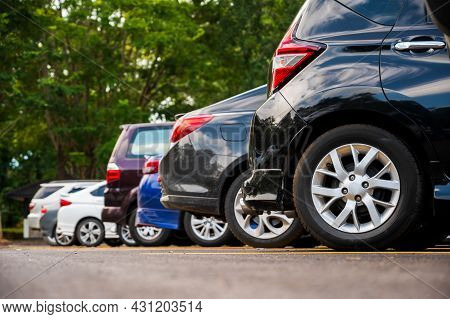 Many Cars Are Parked In A Large Parking Lot. Arranged In A Long Line Was The Time When The Sun Was S