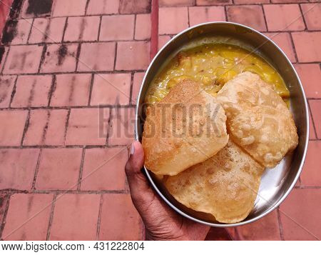 South Indian Male Holding A Plate Filled With Poori Or Puri With Potato Masala. Isolated On Red Back