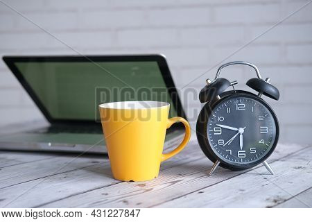 Yellow Color Coffee Mug And Laptop A On Table