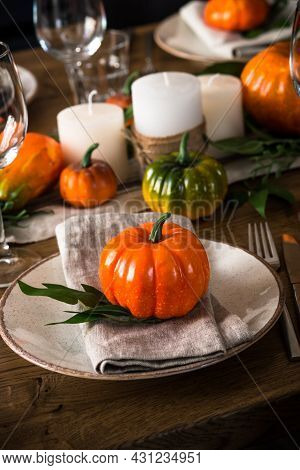 Autumn Table Setting With Plate, Pumpkin And Candles.