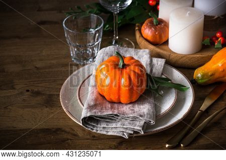 Autumn Table Setting With Plate, Pumpkin And Candles.