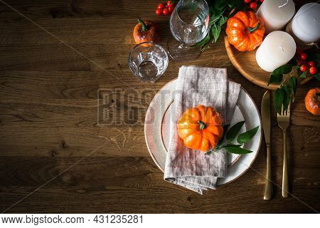 Autumn Table Setting With Plate, Pumpkin And Candles.
