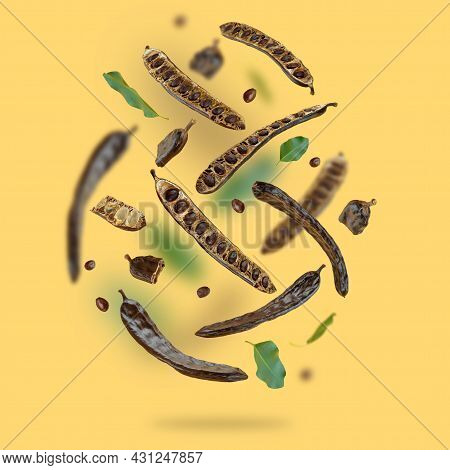 Creative Composition. Floating Organic Carob Pods, Seeds, Leafs On A Beige Food Background. Natural
