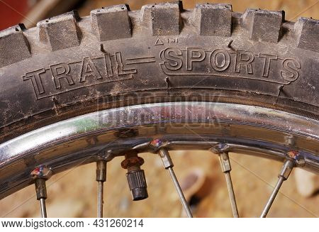 Trail Sports Text On Dusty Tire Of A Motorcycle After Travelling On Rough And Winding Roads. An Imag