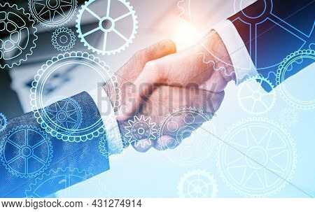 Two Businessman Wearing Formal Suits Are Shaking Hands With Each Other. Blurred Office Workplace In 