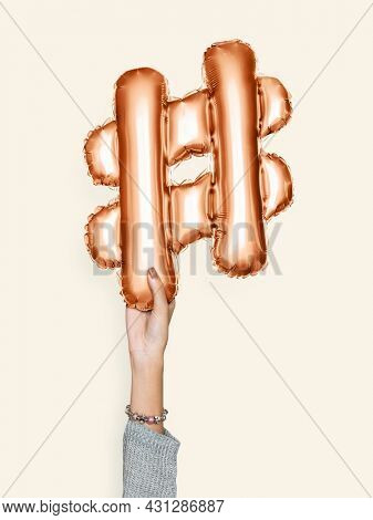 Hand holding balloon symbol hashtag #