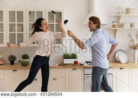 Happy Young Family Couple Having Fun In Modern Kitchen.